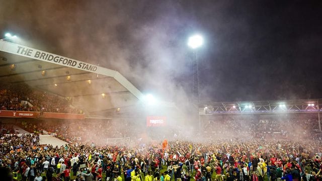 Die Fans von Nottingham Forest feiern auf dem Spielfeld, nachdem ihr Team das Playoff-Finale erreicht hat.