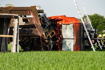 Eine Lok liegt neben den Gleisen auf einem Feld: Bei einem Unfall mit zwei Güterzügen in Südhessen ist ein Lokführer ums Leben gekommen.