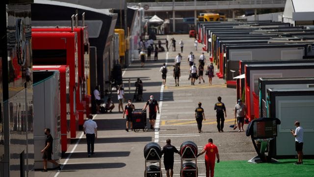 Menschen laufen durch die Paddocks auf der Rennstrecke in Montmelo.