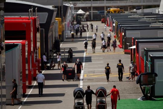 Menschen laufen durch die Paddocks auf der Rennstrecke in Montmelo.