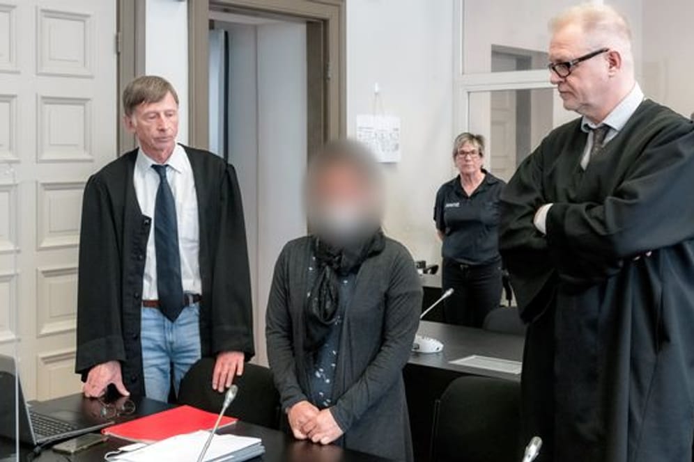 Die Angeklagte IS-Rückkehrerin aus Bremen steht zwischen ihren Verteidigern Jacob Hösl (r) und Johannes Pausch in einem Saal des Oberlandesgericht.