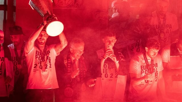 Frankfurts Torwart Kevin Trapp (l) jubelt vom Balkon des Rathauses mit dem Pokal den Fans auf dem Römerberg zu.