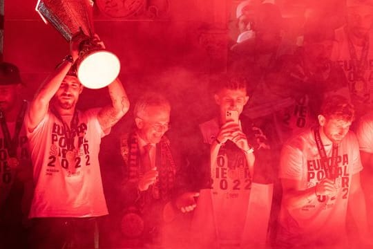 Frankfurts Torwart Kevin Trapp (l) jubelt vom Balkon des Rathauses mit dem Pokal den Fans auf dem Römerberg zu.