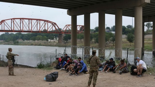 Migranten warten am Rio Grande auf die Ankunft von US-Grenzschutzbeamten.