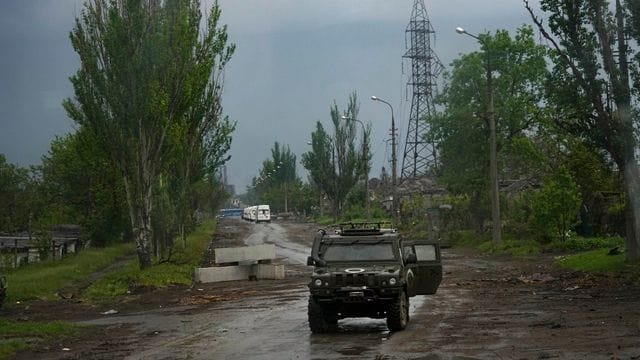 Ein russisches gepanzertes Fahrzeug bewacht die Straße zum belagerten Stahlwerk Azovstal während einer Evakuierung in Mariupol.