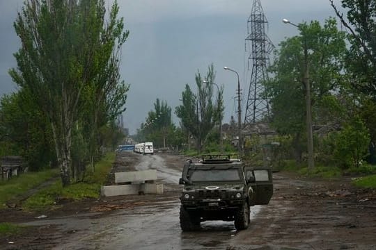 Ein russisches gepanzertes Fahrzeug bewacht die Straße zum belagerten Stahlwerk Azovstal während einer Evakuierung in Mariupol.