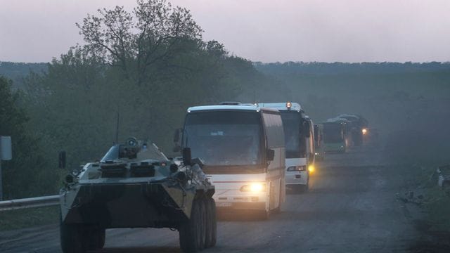 Ein APC der Miliz der sogenannten Volksrepublik Donezk begleitet Busse mit ukrainischen Soldaten zur Strafkolonie in Oljoniwka, nachdem sie das belagerte Stahlwerk Azovstal in Mariupol verlassen haben.
