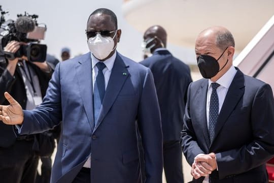 Bundeskanzler Olaf Scholz (r, SPD), wird von Macky Sall, Präsident der Republik Senegal mit militärischen Ehren am Flughafen begrüßt.