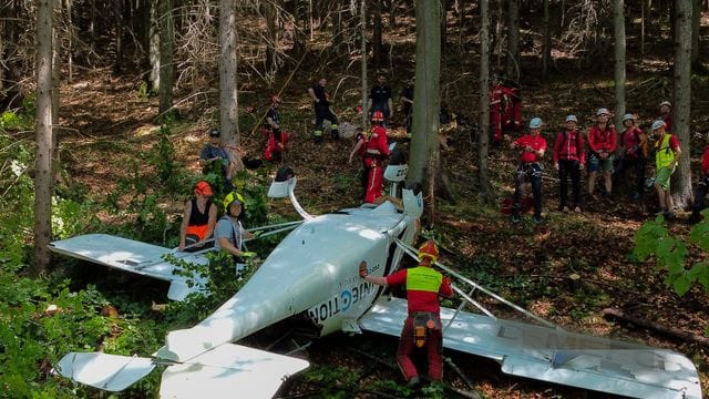 Feuerwehrleute sind neben einem der abgestürzten Flugzeuge im Einsatz.