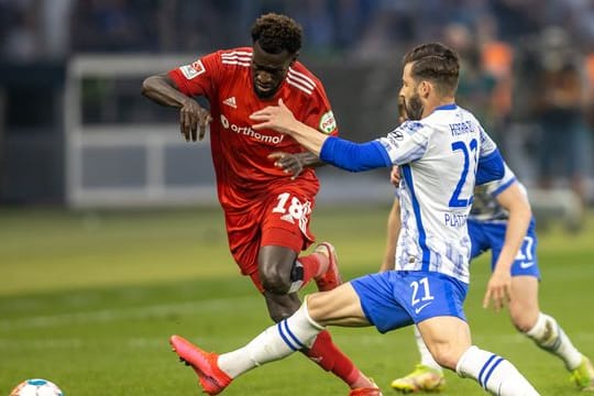 Berlins Marvin Plattenhardt (r) kämpft gegen Bakery Jatta vom Hamburger SV um den Ball.