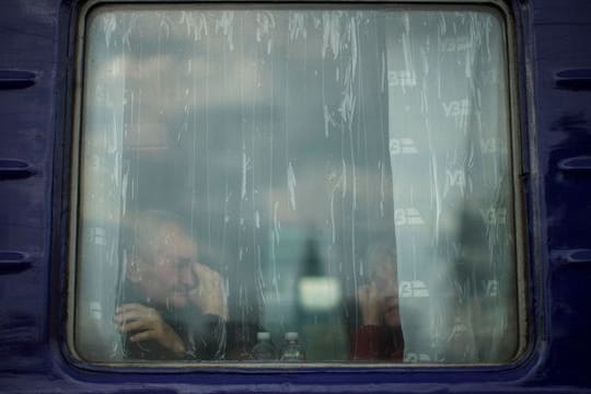 Ein Mann sitzt in einem Evakuierungszug, der den Bahnhof von Pokrowsk in der Ostukraine verlassen soll.