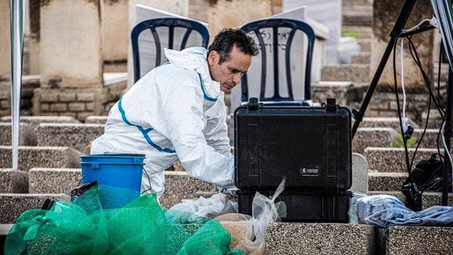 Ein Gerichtsmediziner arbeitet an einem Grab auf dem Friedhof von Petach Tikva in Tel Aviv.