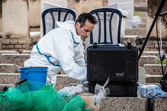 Ein Gerichtsmediziner arbeitet an einem Grab auf dem Friedhof von Petach Tikva in Tel Aviv.