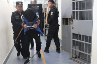 Das Foto aus den Xinjiang Police Files soll Polizisten im Jahr 2018 in einem Umerziehungslager bei einer Festnahme zeigen.