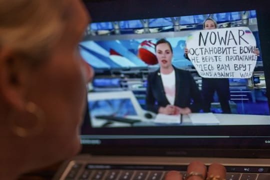 Mit einem Protestplakat und lauten Rufen hatte eine Kriegsgegnerin im russischen Staatsfernsehen für eine Unterbrechung der Hauptnachrichtensendung gesorgt.