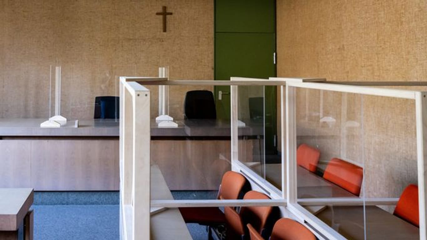 Ein Kreuz hängt im Landgericht München in einem Sitzungssaal.