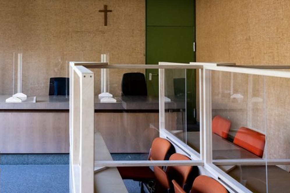Ein Kreuz hängt im Landgericht München in einem Sitzungssaal.