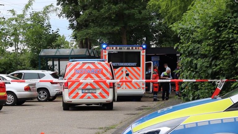 Notarzt und Polizei stehen auf einem Parkplatz in Lienen: In dem Ort wurde ein Mann mit einem Messer getötet.