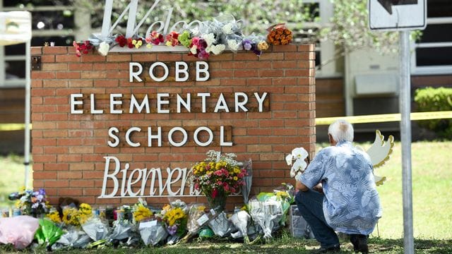 Ein Anwohner legt Blumen vor der Robb-Grundschule im Süden der Stadt Uvalde ab. Ein Anwohner legt Blumen vor der Robb-Grundschule im Süden der Stadt Uvalde ab.