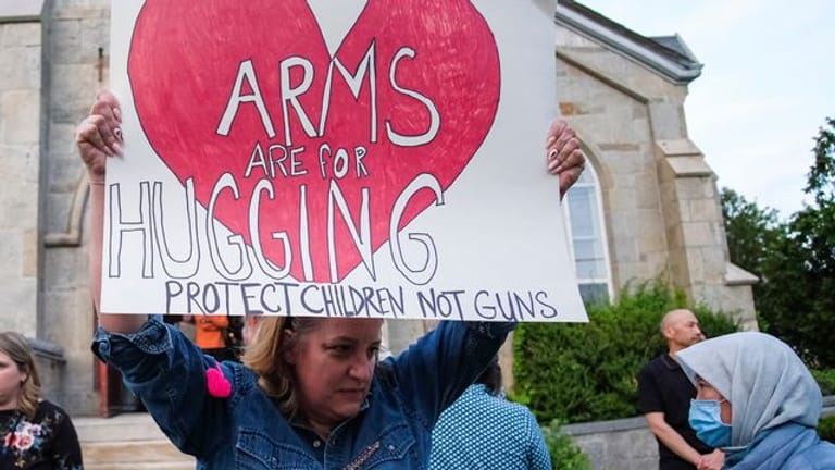 Ein Plakat, das fordert, Kinder zu schützen - und nicht Waffen.