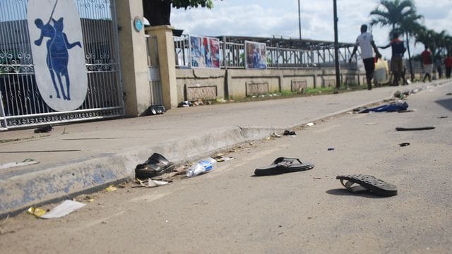 Flip Flops und Sandalen liegen nach einer Massenpanik auf einer Straße. Flip Flops und Sandalen liegen nach einer Massenpanik auf einer Straße.