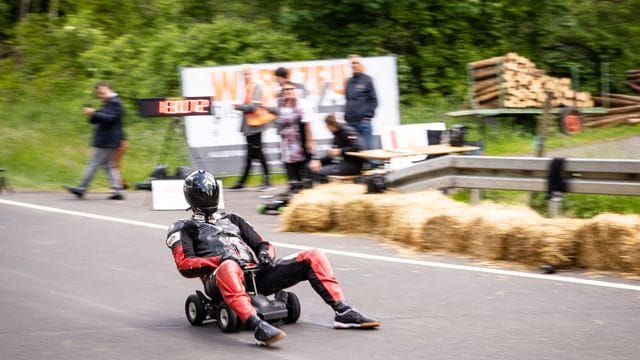 Der Hesse Marcel Paul rast mit seinem modifizierten Bobby Car den Hang hinunter und bremst mit qualmenden Schuhen. Der Hesse Marcel Paul rast mit seinem modifizierten Bobby Car den Hang hinunter und bremst mit qualmenden Schuhen.