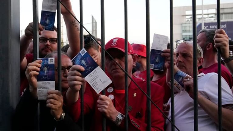 Liverpool-Fans zeigen ihre Eintrittskarten, während sie auf den Einlass ins Stade de France warten.