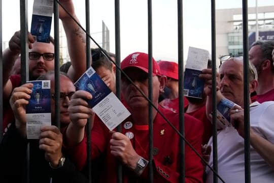 Liverpool-Fans zeigen ihre Eintrittskarten, während sie auf den Einlass ins Stade de France warten.