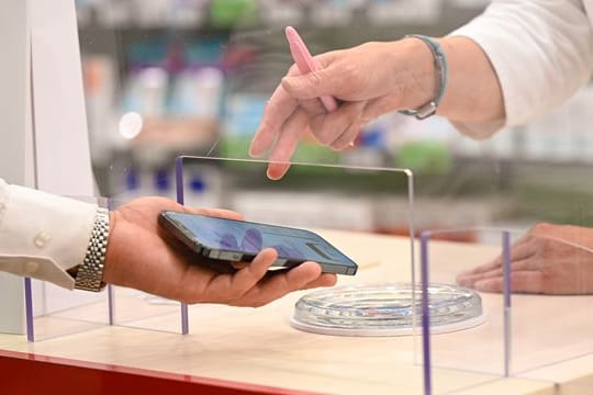 Ein Mann zeigt der Apothekerin sein Rezept auf dem Smartphone (Symbolbild).