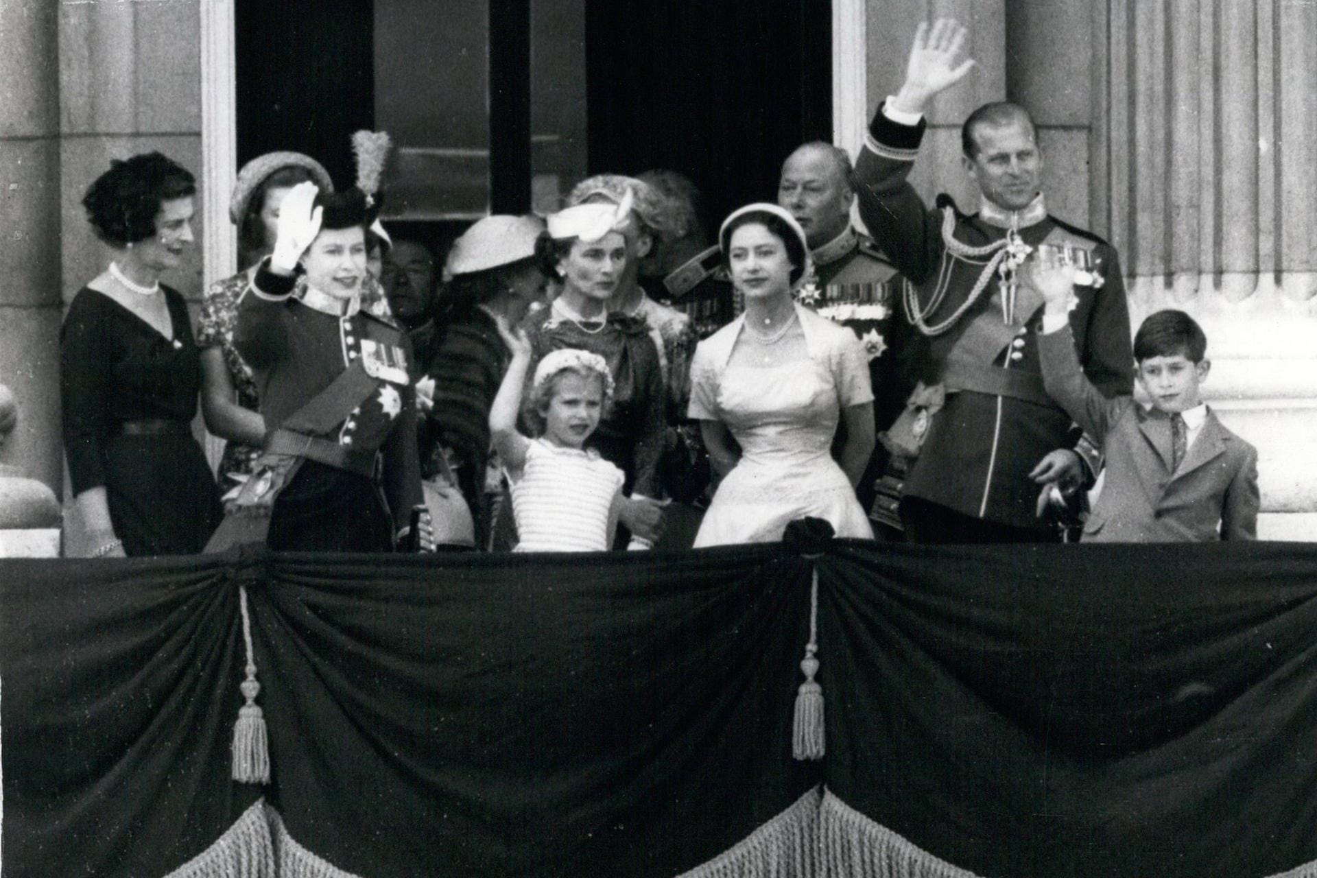 1957: Die Queen und die royale Familie winken vom Balkon des Palasts.