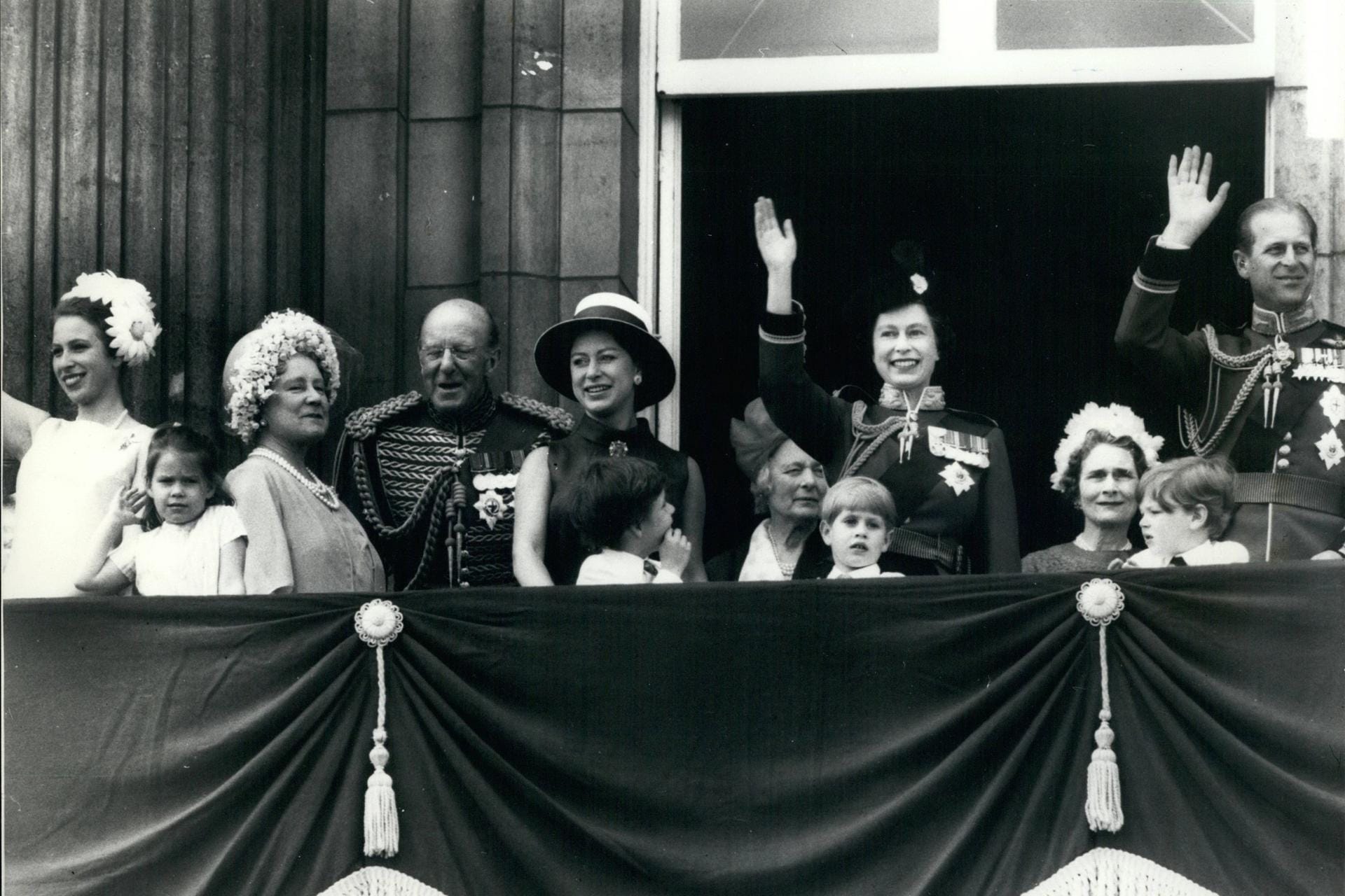 1969: Die Queen steht lachend und winkend auf dem Balkon.