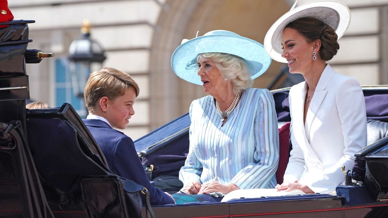 Prinz George (l-r), Camilla, Herzogin von Cornwall und Kate, Herzogin von Cambridge, fahren in einer offenen Kutsche.