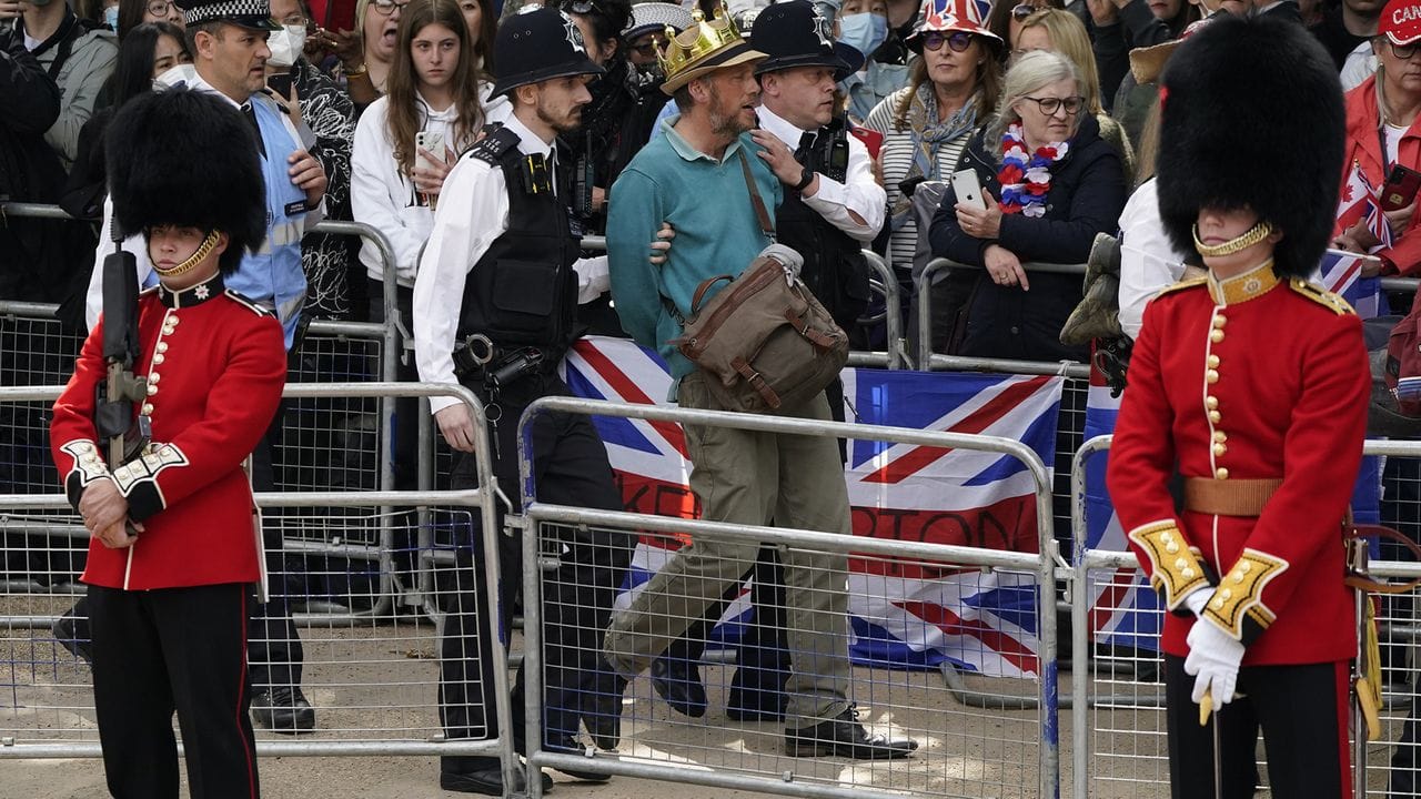 Polizisten entfernen einen Mann, der den Aufmarsch der königlichen Prozession auf der Mall vor der Geburtstags-Parade "Trooping the Colour" störte.
