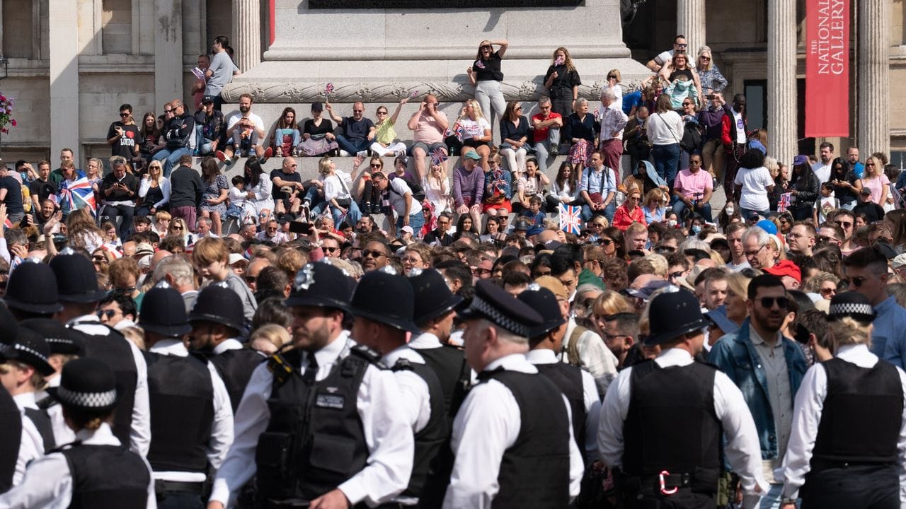 Polizisten stehen vor einer Menschenmenge auf dem Trafalgar Square in London.