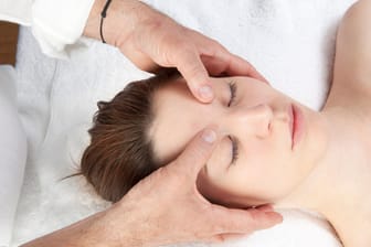 Gesichtsmassage bei Frau: Sanfter Druck auf den richtigen Punkten kann besonders bei Spannungskopfschmerzen lindernd wirken.