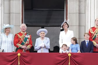 Die Monarchin und ihre Familie schauen vom Palast aus in den Himmel.