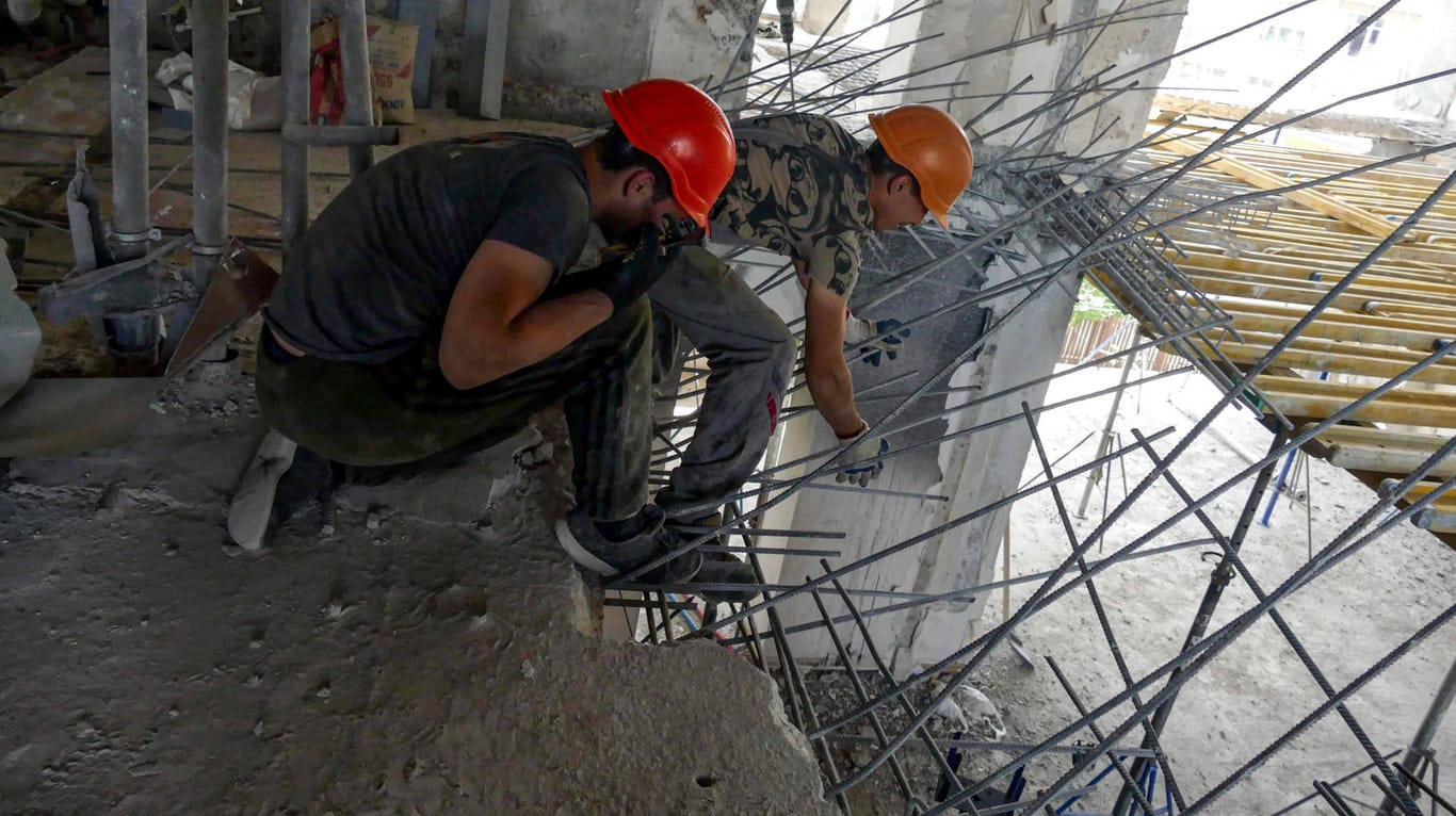 Arbeiter bauen ein von Russland zerstörtes Gebäude in Odessa wieder auf (Symbolbild): Die Inflation zog wegen des russischen Angriffs deutlich an.