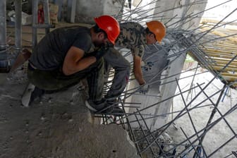 Arbeiter bauen ein von Russland zerstörtes Gebäude in Odessa wieder auf (Symbolbild): Die Inflation zog wegen des russischen Angriffs deutlich an.