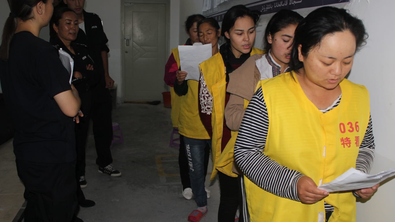 Häftlinge werden in einem "Umerziehungslager" Chinas von der Polizei bewacht: Eine Überlebende berichtet von Zwangssterilisation.