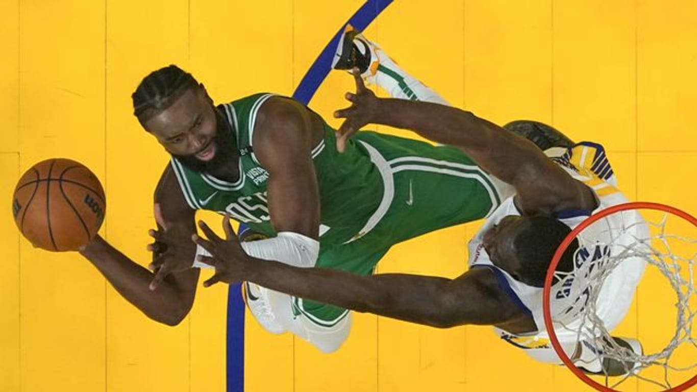 Draymond Green von den Warriors verteidigt am Korb gegen Jaylen Brown (l) von den Celtics.