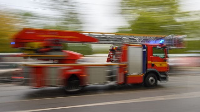 Ein Feuerwehrfahrzeug mit Drehleiter fährt zu einem Einsatz.