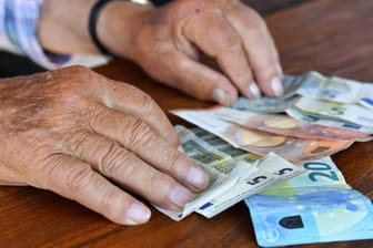 Senior mit Geld auf dem Tisch (Symbolbild): Die Rente wird zum 1. Juli erhöht.