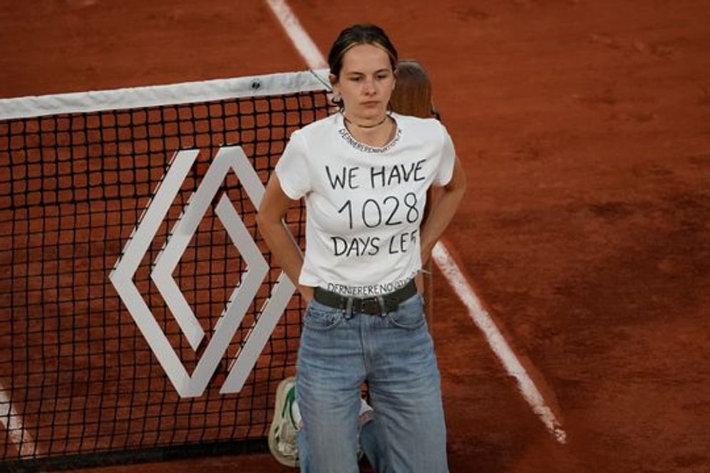 Eine Klimaaktivistin sich während des Halbfinals zwischen Cilic und Ruud ans Netz gebunden.