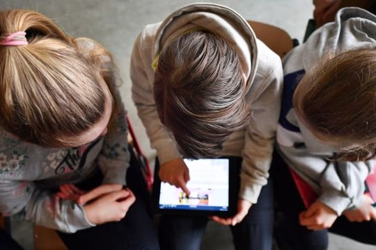 Schüler arbeiten mit einem Tablet.