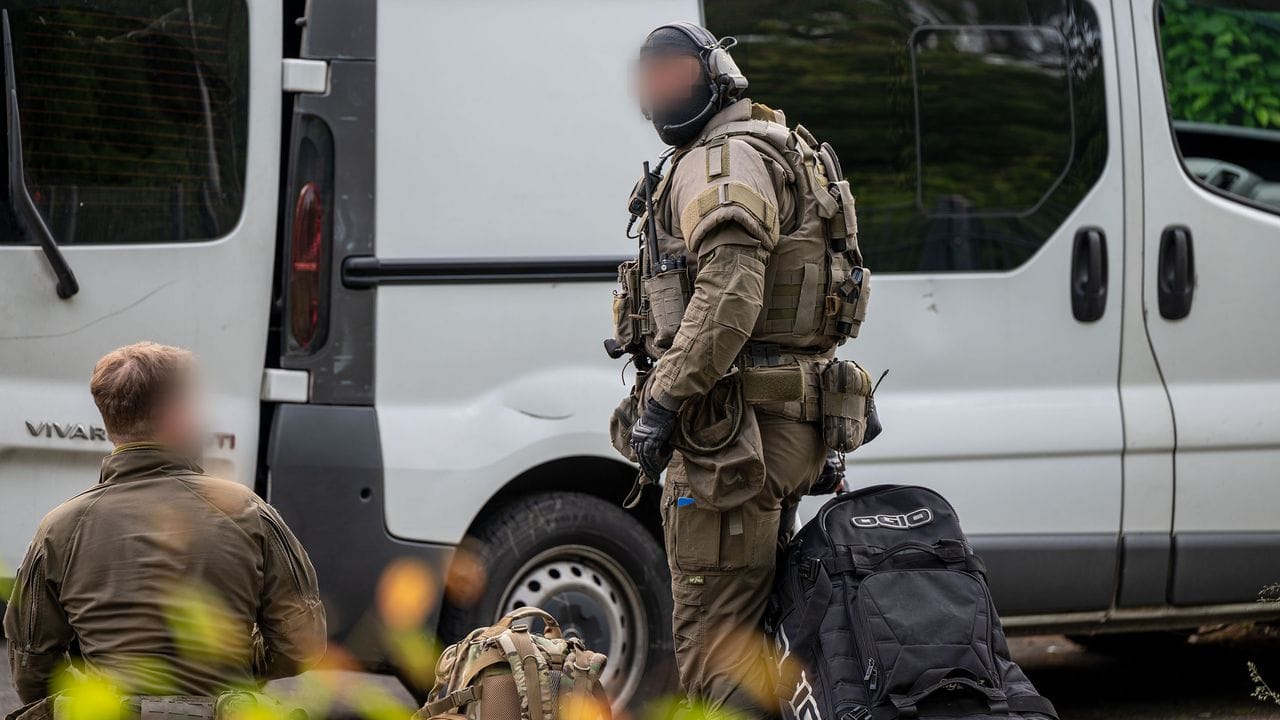 Beamte eines Spezialeinsatzkommandos stehen neben einem Transporter: Zwei Wochen nach dem tödlichen Schuss bei der Kirmes in Lüdenscheid hat die Polizei eine Wohnung durchsucht und eine Person vorläufig festgenommen. Beamte eines Spezialeinsatzkommandos stehen neben einem Transporter: Zwei Wochen nach dem tödlichen Schuss bei der Kirmes in Lüdenscheid hat die Polizei eine Wohnung durchsucht und eine Person vorläufig festgenommen.