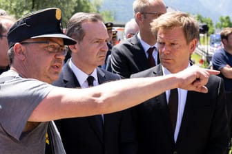 Verkehrsminister Volker Wissing (Mitte) und Bahnchef Richard Lutz (rechts) am Unfallort: Der Minister will die Ursache des Zugunglücks bei Garmisch-Partenkirchen aufklären lassen.