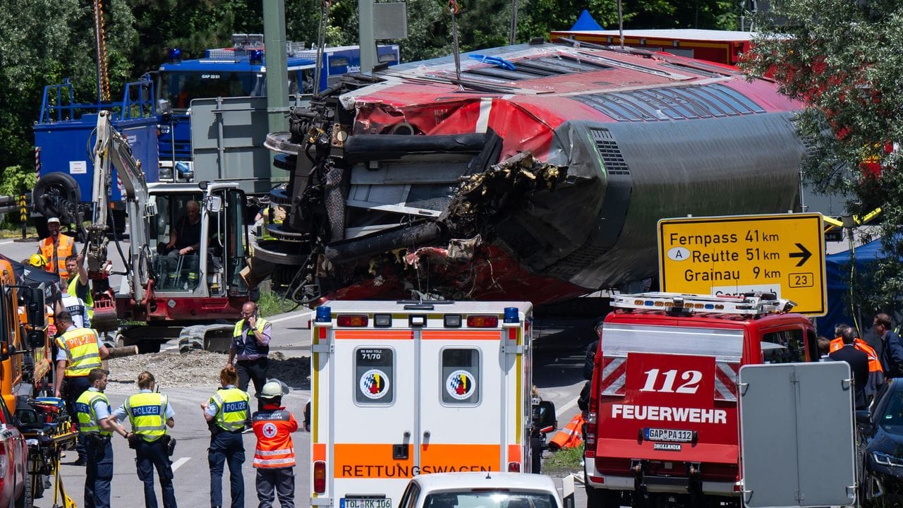 Die Rettungskräfte heben nach dem schweren Zugunglück einen der Waggons an.