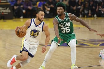 Stephen Curry (l), Guard der Golden State Warriors, zieht zum Korb gegen Marcus Smart, Guard der Boston Celtics.