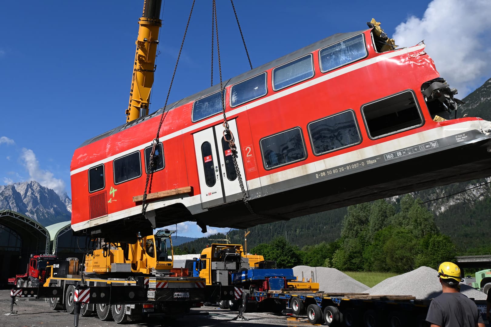 Ein auseinandergeschnittenes Waggonteil wird in einem nahe gelegenen Kieswerk vom Laster gehoben und gelagert.