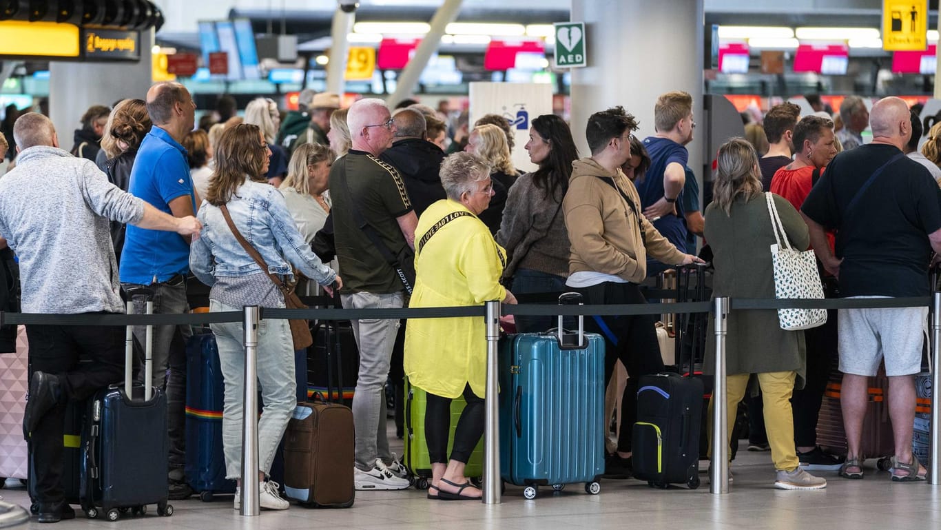 Reisende stehen in der Abflughalle des Flughafens Schiphol Schlange: Seit Wochen kämpft der Flughafen mit großen Problemen bei der Gepäckabfertigung und Sicherheit wegen Personalmangels.